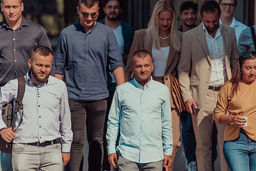 Image showing A diverse group of businessmen and colleagues walking together by their workplace, showcasing collaboration and teamwork in the company.