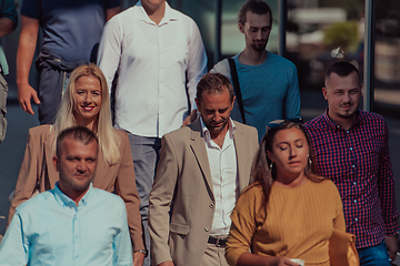 Image showing A diverse group of businessmen and colleagues walking together by their workplace, showcasing collaboration and teamwork in the company.