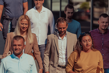 Image showing A diverse group of businessmen and colleagues walking together by their workplace, showcasing collaboration and teamwork in the company.