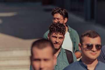 Image showing A diverse group of businessmen and colleagues walking together by their workplace, showcasing collaboration and teamwork in the company.