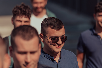 Image showing A diverse group of businessmen and colleagues walking together by their workplace, showcasing collaboration and teamwork in the company.