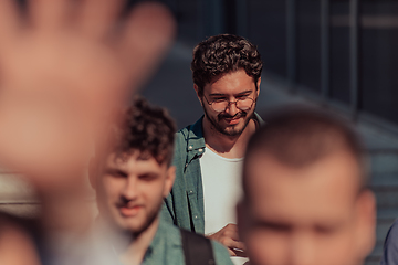 Image showing A diverse group of businessmen and colleagues walking together by their workplace, showcasing collaboration and teamwork in the company.