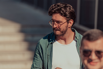 Image showing A diverse group of businessmen and colleagues walking together by their workplace, showcasing collaboration and teamwork in the company.