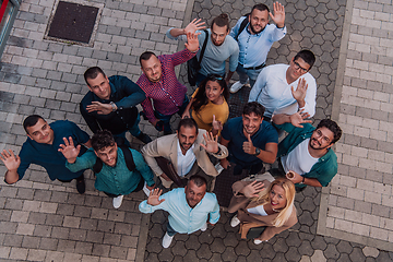 Image showing A top view photo of group of businessmen and colleagues standing together, looking towards the camera, symbolizing unity and teamwork.