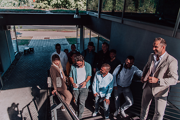 Image showing A diverse group of businessmen and colleagues walking together by their workplace, showcasing collaboration and teamwork in the company.