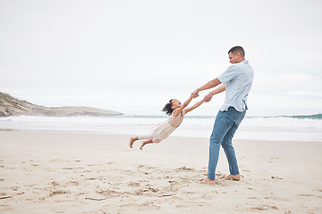 Image showing Swinging, happy and a father and child at the beach for fun, bonding and love in summer for vacation. Playful, laughing and a young dad spinning a girl kid at the ocean for freedom and love together