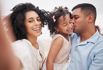 Image showing Selfie, portrait and a family at the beach with a kiss, bonding or fun on a vacation. Happy, travel and a mother, father and girl kid taking a photo at the ocean for summer freedom, love and care