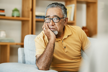 Image showing Face, mental health and thinking with a sad old man on a sofa in the living room of his retirement home. Depression, alzheimer or dementia and a senior person looking lonely with memory nostalgia