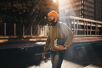 Image showing Man in city, university books and walking on morning commute to campus for education with backpack. Learning, opportunity and college student on urban street with school notebook, knowledge and sun.