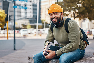 Image showing Portrait of happy man in city, university books and smile on morning relax at campus for education with backpack. Learning, studying and college student sitting on urban sidewalk with confidence.