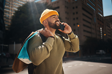 Image showing Man, phone call and shopping bag outdoor with travel, walking and talking of deal, discount or retail sale in street. African person thinking of gift choice, package and mobile communication in city