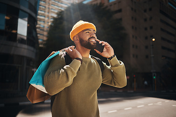 Image showing Man, phone call and shopping in city with travel, walking and talking of student deal, discount or online sale in street. Happy african person with retail bag and mobile communication or outdoor chat