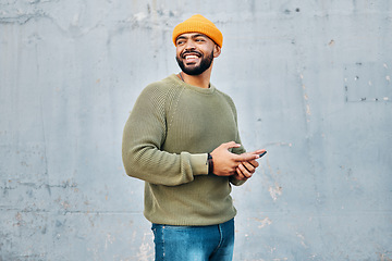 Image showing Cellphone, happy and young man by wall networking on social media, mobile app or the internet. Technology, smile and male person from Colombia scroll on website with phone in city by gray background.