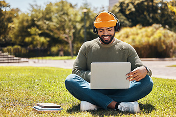 Image showing Student, laptop and headphones in university park, college or school for research, studying and e learning on grass. African man on computer, listening to music or campus podcast for online education