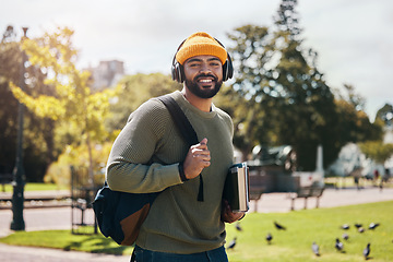 Image showing Portrait of happy man on campus with books, headphones and backpack on morning commute for education. Learning, studying and college student in park with podcast, music or streaming online on walk.