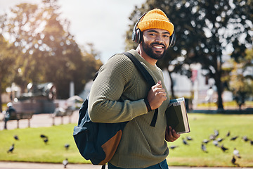 Image showing Student, headphones and backpack for outdoor education, college or university podcast in park or campus. Portrait of african man walking, travel and books with study, learning and listening to music