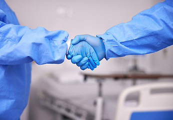 Image showing Doctor, team and handshake with gloves in partnership, meeting or introduction together at hospital. Closeup of medical nurse or employees shaking hands in teamwork for deal or agreement at clinic