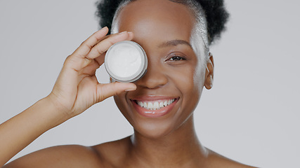 Image showing Happy black woman, face and skincare cream for beauty, cosmetics against a studio background. Portrait of African female person or model smile with lotion, moisturizer or creme for facial treatment