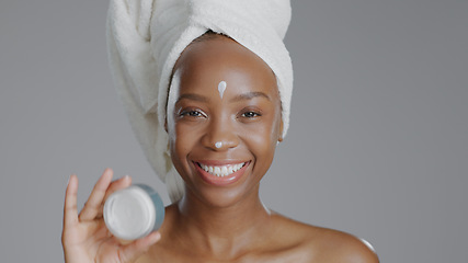 Image showing Woman, moisturizer and smile in portrait for skincare or beauty, health and wellness or dermatology. Happy black person, skin and cosmetics with glow, care and cream in studio by gray background