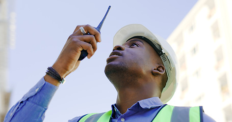 Image showing Communication, radio and construction worker, man or manager for project management in urban city. African builder in engineering inspection, building progress or architecture survey on walkie talkie