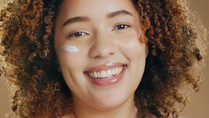 Image showing Skincare, black woman and cream on face for dermatology, beauty or happiness on brown background in studio. Skin, care or happy portrait with cosmetics, lotion or sunscreen for wellness or confidence
