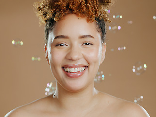 Image showing Happy woman in portrait, bubbles and skincare for beauty, natural cosmetics and glow on brown background. Dermatology, wellness for skin and liquid soap with self care and anti aging in studio