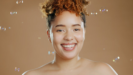 Image showing Woman in portrait, bubbles and skincare for beauty, happy with natural cosmetics and glow on brown background. Dermatology, wellness for skin and liquid soap with self care and anti aging in studio