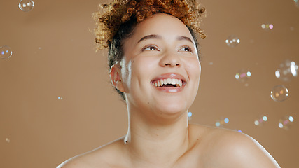 Image showing Happy woman, bubbles and skin for beauty, happy with natural cosmetics and glow on brown background. Dermatology, wellness with skincare and liquid soap for self care and anti aging in studio