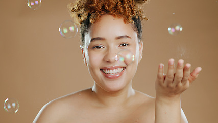 Image showing Woman in portrait, bubbles and natural beauty, happy with cosmetics for skincare and glow on brown background. Dermatology, wellness for skin and liquid soap with self care and anti aging in studio