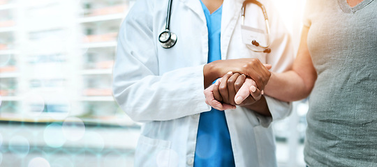 Image showing Closeup, doctor and patient with support, holding hands and teamwork with lens flare, banner and healthcare. People, medical professional and woman with medicare, hospital and compassion with empathy