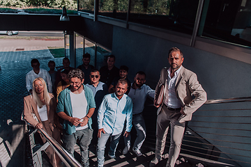 Image showing A diverse group of businessmen and colleagues walking together by their workplace, showcasing collaboration and teamwork in the company.