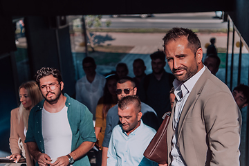 Image showing A diverse group of businessmen and colleagues walking together by their workplace, showcasing collaboration and teamwork in the company.