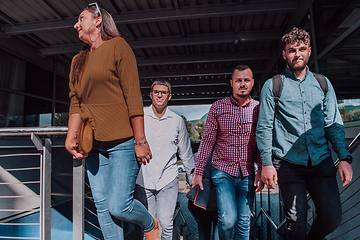 Image showing A diverse group of businessmen and colleagues walking together by their workplace, showcasing collaboration and teamwork in the company.