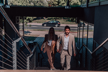 Image showing Modern business couple after a long day's work, walking together towards the comfort of their home, embodying the perfect blend of professional success and personal contentment.