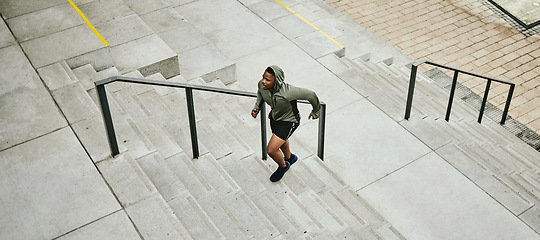 Image showing Fitness, city and black man running on stairs outdoor, exercise and training healthy body in urban town top view. Sports, cardio and African athlete on steps for workout, energy and jog for wellness