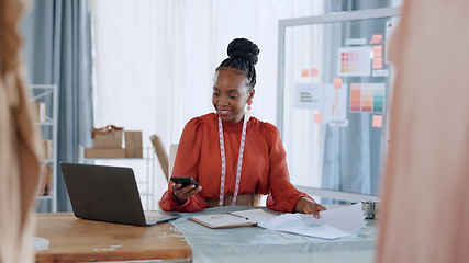 Image showing Fashion designer, laptop and black woman with phone for clothes brand, logistics and supply chain in workshop. Retail, smartphone and person online for creative startup, small business and store