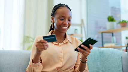 Image showing Happy black woman, phone and credit card on sofa for payment, online shopping or fintech at home. African female person smile with debit and mobile smartphone for transaction, bank app or ecommerce