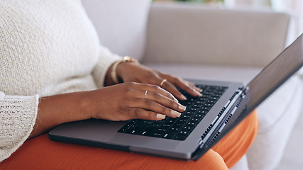 Image showing Hands, laptop and a person typing on a sofa in the living room of her home for email communication. Computer, keyboard and an adult typing a social media post or article for her online blog closeup