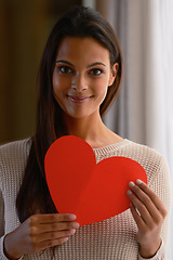 Image showing Woman, face and red heart paper in house or home for valentines day, cardiology surgery organ donor or support. Portrait, smile or happy Indian person with love cut out for trust, comfort or kindness