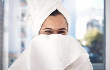 Image showing Portrait, towel and woman after a shower, happy and relax while hiding face and grooming in her home. Shy, girl and beauty, skincare and routine in bathroom for cleaning, hygiene and fun in New York