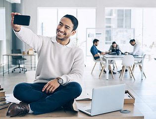 Image showing Selfie, phone and businessman sitting on desk in meeting with team, staff and working in corporate office. Startup, happiness and young Asian male worker using smartphone to take picture in workplace