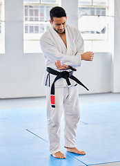 Image showing Karate injury, hurt and elbow pain for a man athlete holding painful arm at the gym. Active, Sport and athletic male suffering from muscle inflammation due to an exercise, fight training or workout