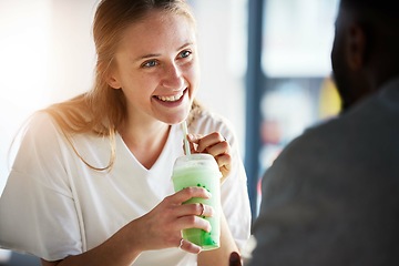 Image showing Woman, smile and smoothie on date in restaurant with man in interracial relationship, love and care. Girl, happy and drinking milkshake for health, nutrition or detox in conversation with black man