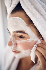 Image showing Facial, skincare and woman peeling a face mask for beauty in a grooming treatment with dermatology products. Relaxed, cream and young girl with tissue to wipe acne lotion cosmetics in a bathroom