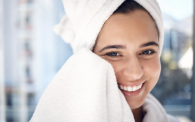 Image showing Face, shower and hygiene with a woman in the bathroom of her home for cleaning, wellness or skincare. Portrait, smile and towel with a happy female drying her skin after washing or facial cleansing