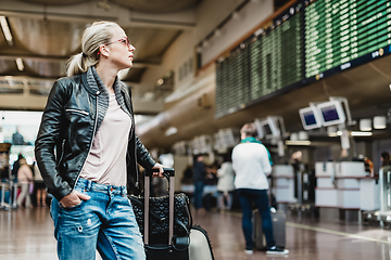 Image showing Female traveller checking flight departures board.