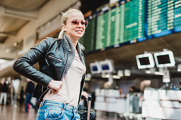 Image showing Female traveller checking flight departures board.