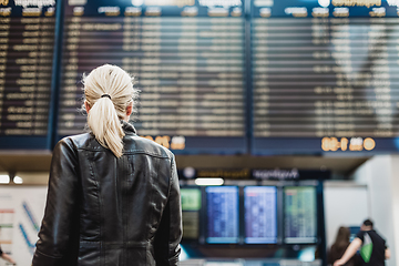 Image showing Female traveller checking flight departures board.