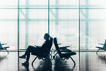 Image showing Woman in transit waiting on airport gate.