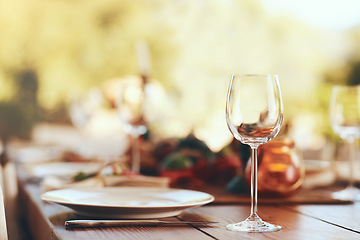 Image showing Empty wine glass, plate and cutlery on a table for a dinner, party or event at a restaurant. Glass, table setting and dinnerware for an outdoor luxury festive, holiday or celebration banquet or feast